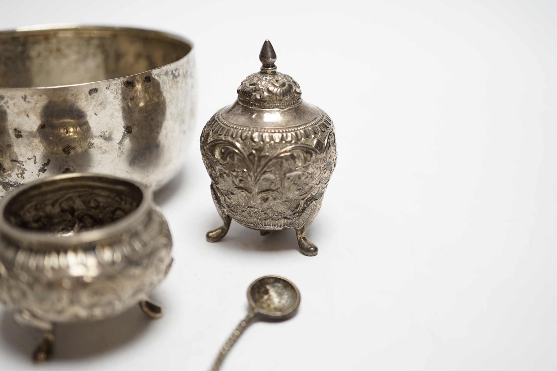 A Thai white metal bowl, diameter 82mm, a Chinese white metal napkin ring, a white metal three piece cruet set and four assorted spoons including George IV teaspoon by William Bateman.